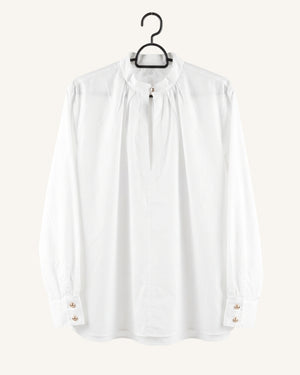 A white long-sleeve blouse with a gathered high neck and buttoned cuffs, hanging on a black hanger against a light beige background.