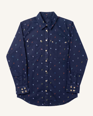A navy blue long-sleeve button-up shirt with a small repeating anchor pattern in red, blue, and white, displayed flat against a light cream background.
