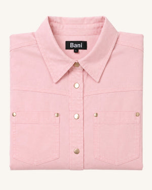 A folded light pink long-sleeve button-up shirt with two chest pockets and gold-tone metal snap buttons, shown on a plain off-white background. The brand label 'Bani' is visible inside the collar.