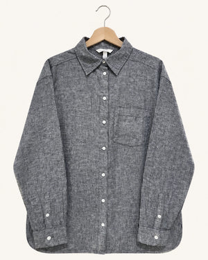 A dark gray textured long-sleeve button-up shirt with a chest pocket, hanging on a wooden hanger against a light cream background.